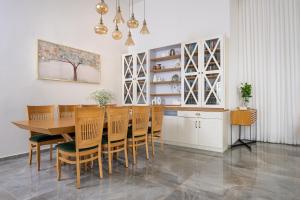 a dining room with a wooden table and chairs at לה וילא - וילה מדהימה עם בריכה פרטית וג'קוזי in Sderot