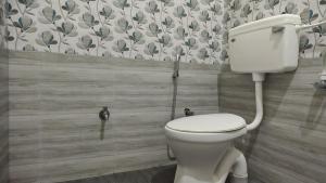 a bathroom with a white toilet in a room at Aruna homes Thanjavur in Thanjāvūr +1 photo