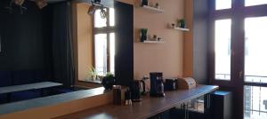a counter in a room with two windows at Rembrandt Hostel in Kraków