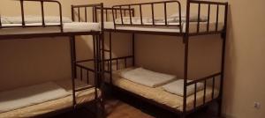 a room with three bunk beds in a room at Rembrandt Hostel in Kraków