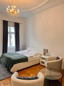 ein weißes Schlafzimmer mit einem Bett und einem Kronleuchter in der Unterkunft REMA Apartments 10702 in Wien