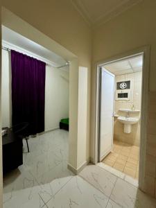 een badkamer met een wastafel en een paars gordijn bij Sultan Beach House in Muscat