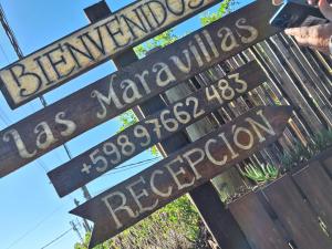 un montón de carteles callejeros en un poste en Posada Las Maravillas, en Punta del Diablo
