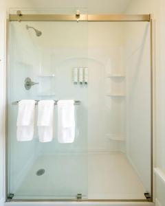 a bathroom with a glass shower with white towels at Riggs House Restored 1908 Home in Maquoketa