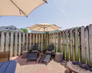a patio with chairs and an umbrella next to a fence at Riggs House Restored 1908 Home in Maquoketa