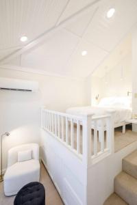 a white room with a bed and a chair at Riggs House Restored 1908 Home in Maquoketa