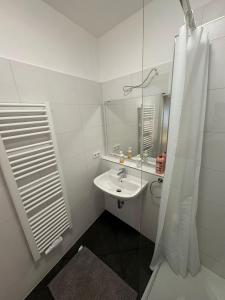 a white bathroom with a sink and a mirror at F3 - 1 Zimmer Wohnung in Offenbach