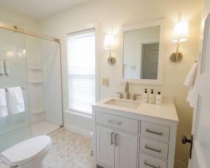 a bathroom with a sink and a toilet and a shower at Riggs House Restored 1908 Home in Maquoketa +33 photos
