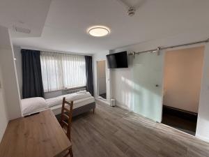 a room with a bed and a table and a tv at Hotel am Park in Braunschweig
