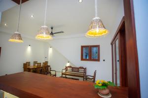 a dining room with a table and several lights at Villa Claudia Nimal's kitchen in Ahangama