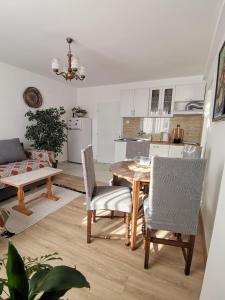 Una cocina y un comedor con mesa y sillas. en Apartman Sigma, en Nova Varoš