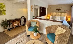 ein Hotelzimmer mit einem Bett und zwei Stühlen in der Unterkunft Koho SXM - ex Hevea Hotel in Grand Case