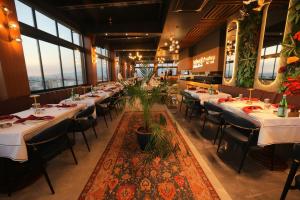 a dining room with tables and chairs and windows at Best Western Izmir Hotel in İzmir