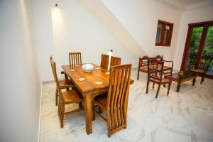 a dining room with a wooden table and chairs at Villa Claudia Nimal's kitchen in Ahangama +40 photos
