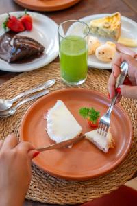 トランコーゾにあるPousada Por do Sol Trancosoの食卓の上で一皿を食べる者