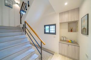 T'ung-koにある愛旅行民宿の白い壁とウッドフロアの家の階段