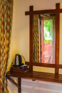 een spiegel op een tafel met een theepot erop bij Ella Mc Queen Homestay in Ella