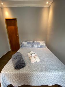 a bed with two rolled up towels on it at Pousada Recanto - Cabo Frio - Unamar - Condominio Florestinha in Cabo Frio
