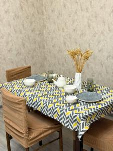 a dining room table with a yellow and blue table cloth at Romantic place in Darkhon