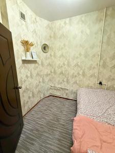 a bedroom with a bed and a tiled wall at Romantic place in Darkhon