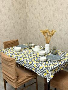 a dining room table with a yellow and blue table cloth at Romantic place in Darkhon