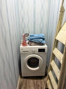 a washing machine in a laundry room with a ladder at Romantic place in Darkhon +6 photos