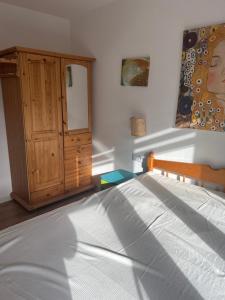 a bedroom with a bed and a wooden cabinet at Ruczaj Cozy Room in Krakow