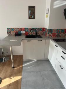 a kitchen with white cabinets and a sink at Ruczaj Cozy Room in Krakow +6 photos