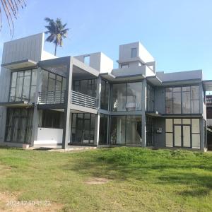 a large building with a palm tree in front of it at Luxe Diamond Villa in Matara