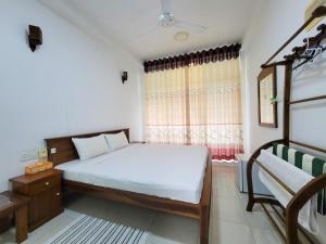 ein kleines Schlafzimmer mit einem Bett und einem Fenster in der Unterkunft Nuwan Inn in Hikkaduwa + 17 Fotos