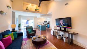 un salon avec un canapé et une télévision à écran plat dans l'établissement Modern Beach Home with Pool Steps Away, à South Padre Island