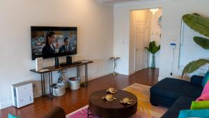 un salon avec un canapé et une télévision dans l'établissement Modern Beach Home with Pool Steps Away, à South Padre Island 112 autres photos