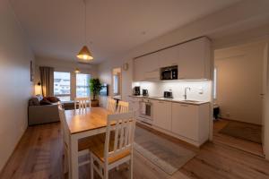 a kitchen and living room with a wooden table and a dining room at Snowflake XII Family rooms in Rovaniemi
