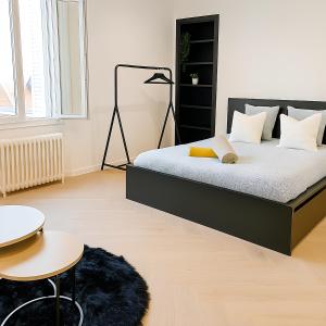 a bedroom with a bed and a table and a chair at Corderie in Rouen