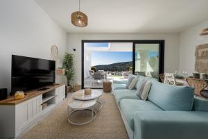 a living room with a blue couch and a tv at Golden View 2460 in Manilva