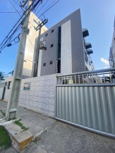 a fence in front of a tall building at Apt 202B- 2 quartos climatizado em Ponta de Campina in Cabedelo