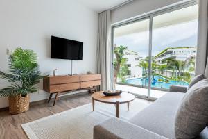 ein Wohnzimmer mit Sofa und Fernseher in der Unterkunft The Leaf C108 in Playa del Carmen