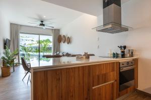 eine Küche mit Holzschränken und einem Herd mit Backofen in der Unterkunft The Leaf C108 in Playa del Carmen