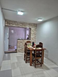 une salle à manger avec une table et quelques chaises dans l'établissement Casa Dormitório na Cidade Nova 8 próxima da Vila cop 30, à Ananindeua
