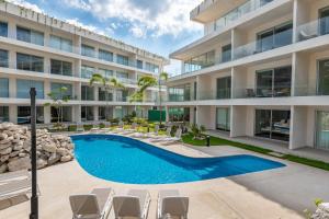 eine Außenansicht eines Gebäudes mit einem Swimmingpool in der Unterkunft The Leaf C108 in Playa del Carmen