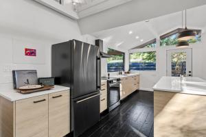 a kitchen with a stainless steel refrigerator and wooden cabinets at A-Frame Villas & Lodges LLC in Kitengela 