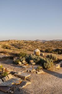 a group of tables and benches in the desert at Berber Beldi Camp in Imsouane