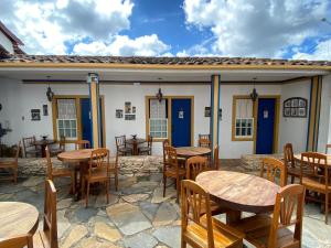 d'une terrasse avec des tables et des chaises en bois. dans l'établissement Pousada Relíquias do Tempo, à Diamantina