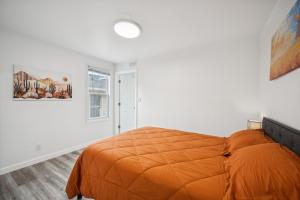 Un dormitorio con una cama naranja en una habitación blanca. en ModPod 3, 