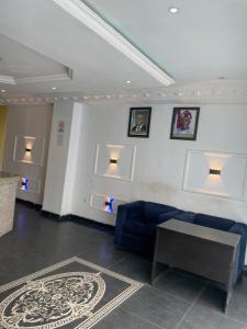 a living room with a blue couch and a table at BOSS HOTELS & SUITES in Lagos