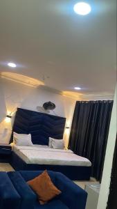 a bedroom with a large bed and a couch at BOSS HOTELS & SUITES in Lagos
