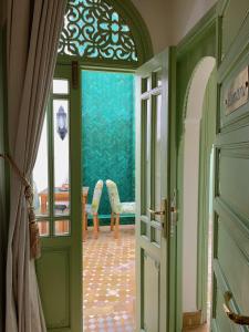 an open door to a room with green walls at Riad Assouel et Spa By La Siredrah in Marrakech
