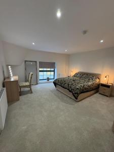 a large bedroom with a bed and a chair at The Old Bakehouse, central historical Beverley in Beverley