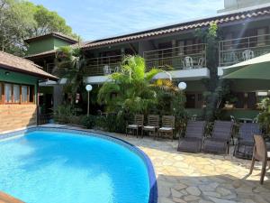 a hotel with a swimming pool in front of a building at Pousada Morada da Praia - Ubatuba -Praia Grande in Ubatuba
