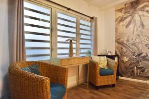 een badkamer met 2 stoelen, een wastafel en een raam bij Koho SXM - ex Hevea Hotel in Grand Case +64 foto's